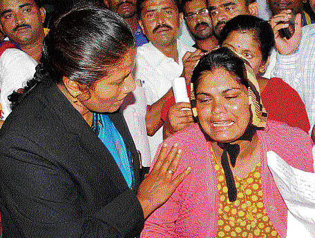 State Women's Commission chairperson Manjula Manasa consoles the baby's mother in Hassan on Wednesday. DH PHOTO