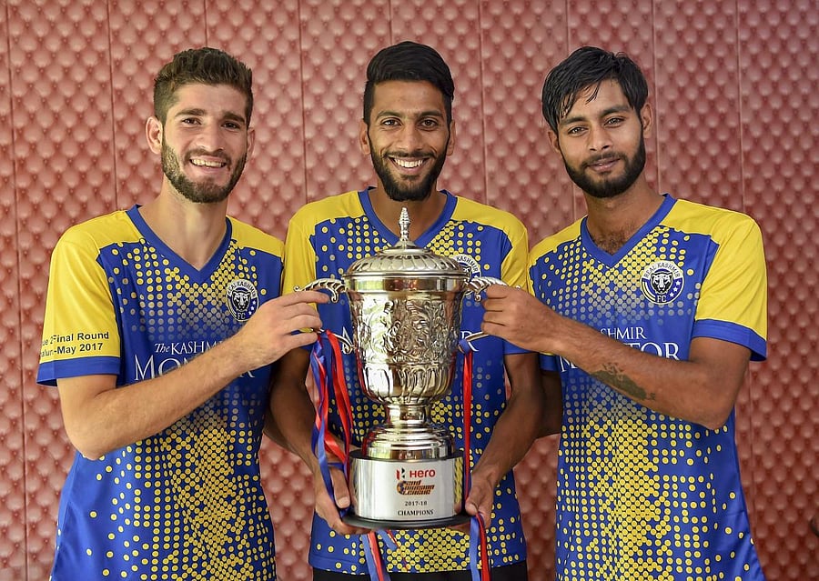 Real Kashmir FC players pose with the second division league trophy in New Delhi. PTI Photo