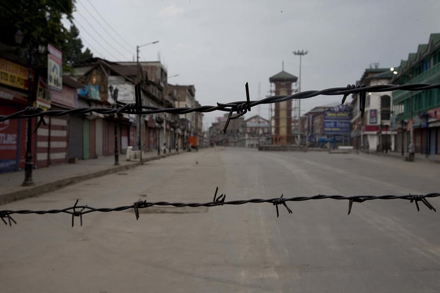 In this Tuesday, Aug 6, 2019 photo, a deserted street is seen through a barbwire set up as blockade during curfew in Srinagar. (AP/PTI Photo)