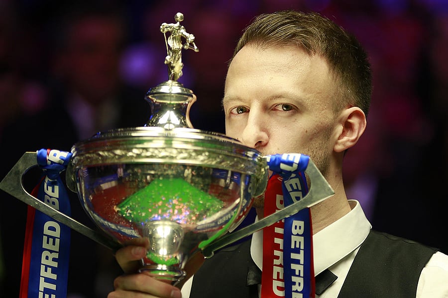 Judd Trumps kisses the Snooker World Championship trophy after beating John Higgins in the final on Monday.