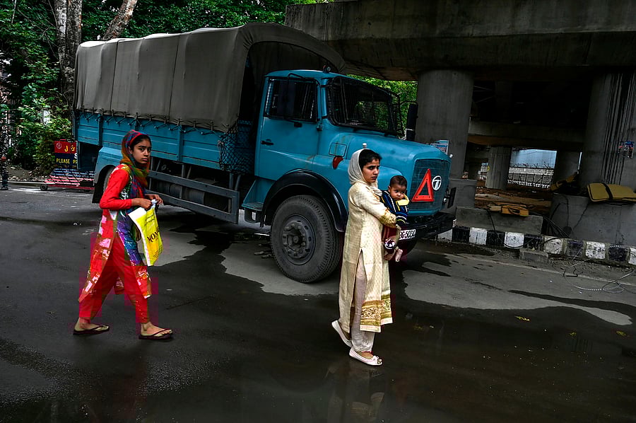 Kashmiri pedestrians walk past a security personnel vehicle in Srinagar. (AFP Photo)