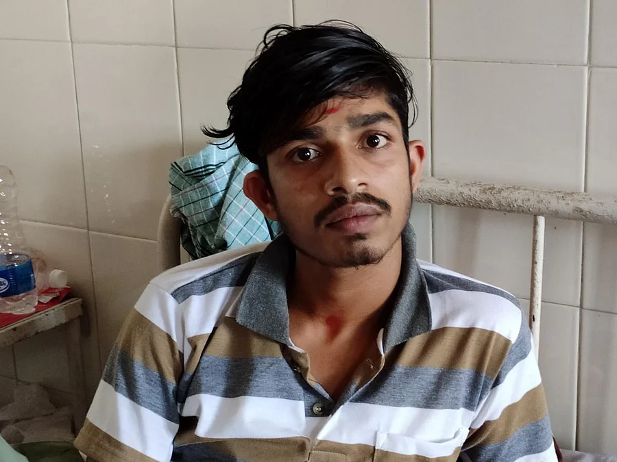 K R Satish, a 20-year-old boy from Thora village, who tried to save his friend's family buried under a landslide, almost losing his own life undergoing treatment with broken feet, at Government Hospital, Virajpet on Tuesday. (DH Photo/ B H Shivakumar)