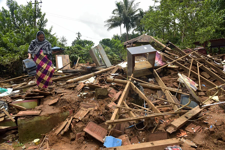P M Jameela tries to salvage belongings from the debris of her house which was ruined in rain at Bethri village in Virajpet taluk of Kodagu district. (DH Photo/B H Shivakumar)