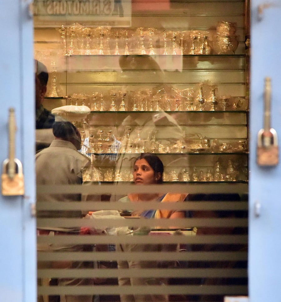 Police conduct an investigation at Samrat Jewels store located at Palace Guttahalli. DH Photo/Janardhan B K