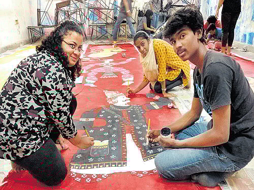 Students of Karnataka Chitrakala Parishath work on the Kannada folk art theme for Chitra Santhe. DH PHOTO