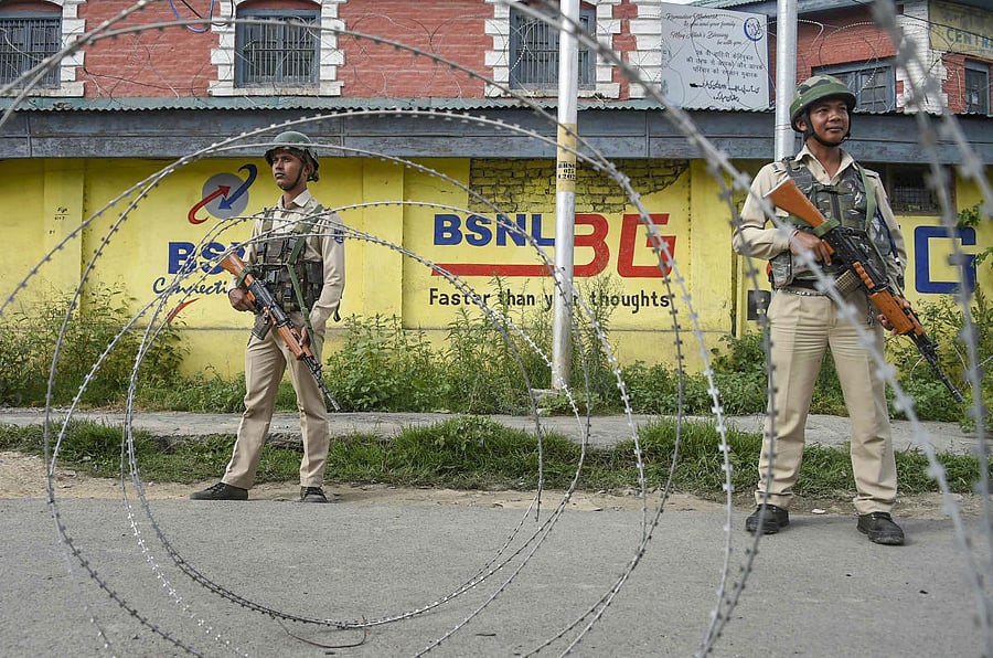 Srinagar: Security personnel stand guard near a blocked road during restrictions following the abrogation of the provisions of Article 370, in Srinagar, Friday, Aug 16, 2019. (PTI Photo)