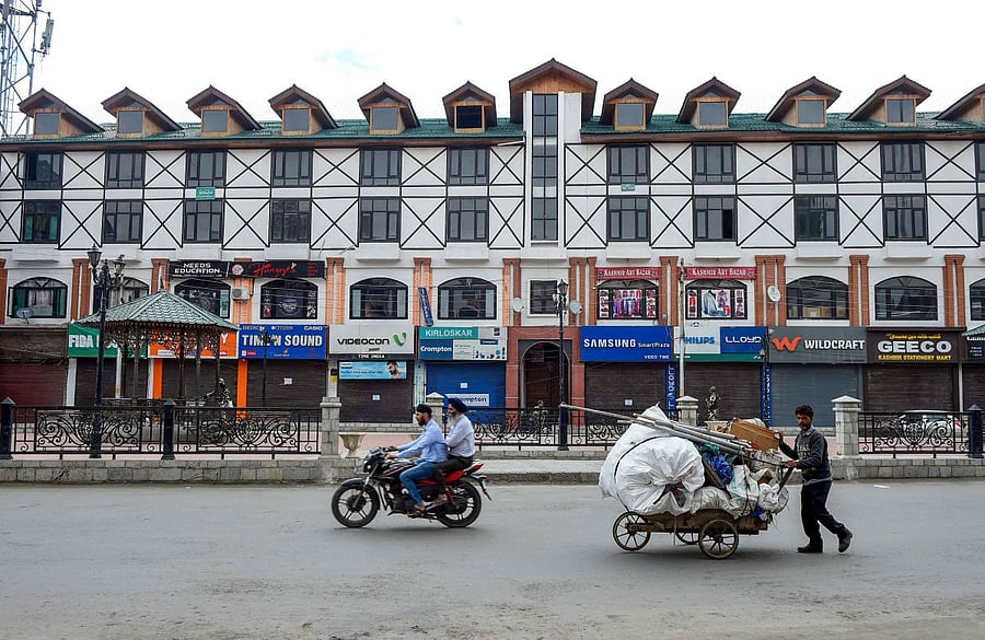 Srinagar: A man pushes his cart through a deserted Lal Chowk area, in Srinagar, Wednesday, Aug. 28, 2019. PTI Photo