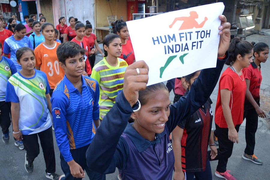 Indian students hold placards as they take part in a walk the first day of the "Fit India movement" scheme launched by Indian prime minister Narendra Modi
