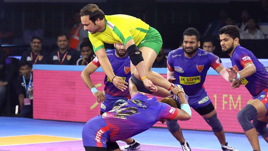 Manjit Chillar of Tamil Thalaivas tries to escape Dabang Delhi players. (DH Photo)