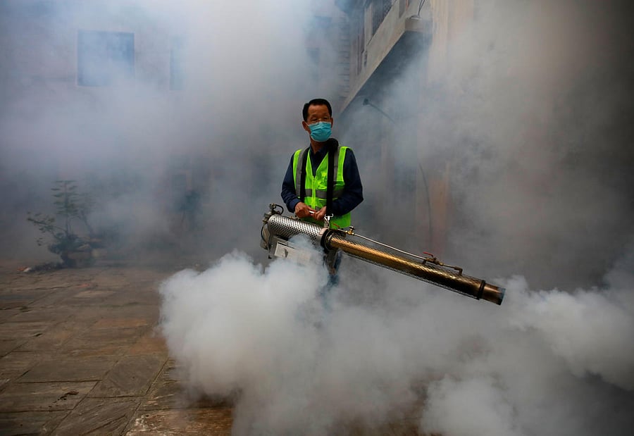 A worker fumigates a resident area to prevent the spread of the dengue fever and other mosquito-borne diseases in Kathmandu, Nepal. (Photo by Reuters)