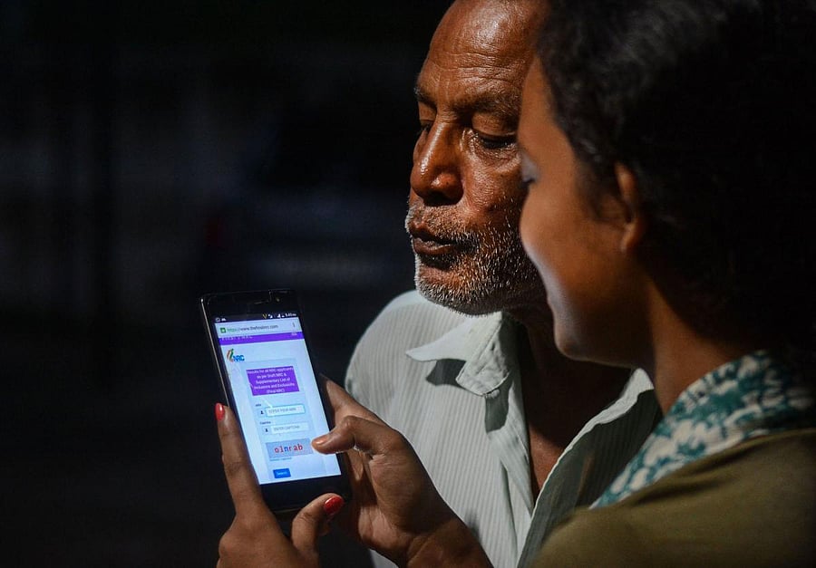 Residents check the complete names of the family members in National Register of Citizenship (NRC) which released online, in Guwahati (PTI File Photo)