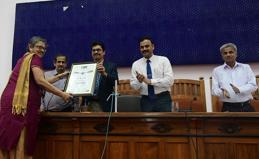 Mangalore University Vice Chancellor Prof P S Yadapadithaya presents the citation of rating of Mangalore University as a ‘Four Star Institution’ to IQAC Director Prof Kishori Nayak during the Academic Council meeting in Mangaluru on Wednesday.