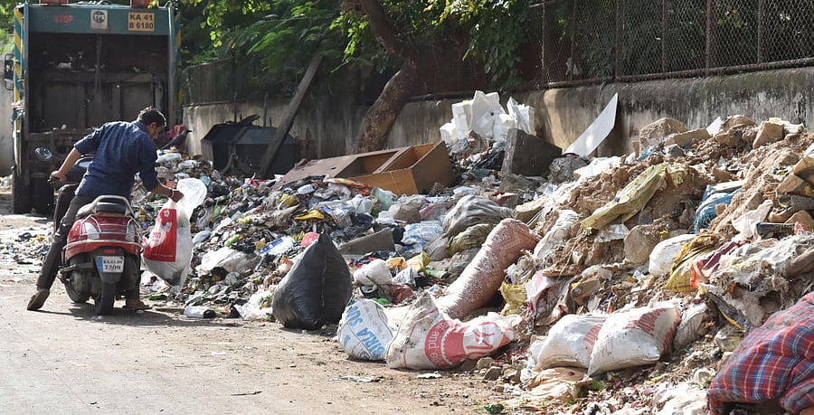 A man dropping of garbage near St Xavier School premises at Shivajinagar in Bengaluru on Thursday, September, 2019. Photo by B K Janardhan