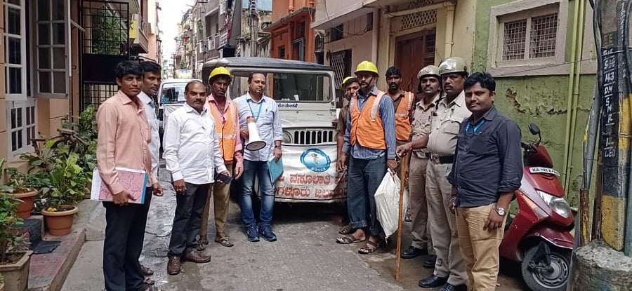 Blaring loudspeakers, BWSSB officials set out to collect pending bills in VV Puram on Wednesday. Special Arrangement