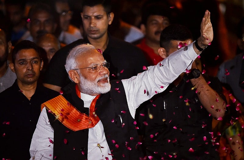 Prime Minister Narendra Modi waves at BJP supporters as he is accorded a grand welcome on his arrival after the week-long US visit. (PTI Photo)