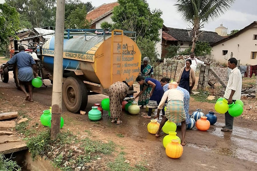 People collect water from tanker at Hosahalli in Kadur taluk. 