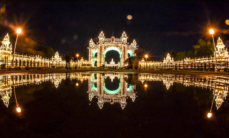 Reflection of the Mysuru Palace, from Jayamarthanda Gate, on the Exhibition Grounds side, all decked up for the Dasara celebration, in Mysuru, on Tuesday. It rained for some time on Tuesday evening. (DH Photo/B R Savitha)