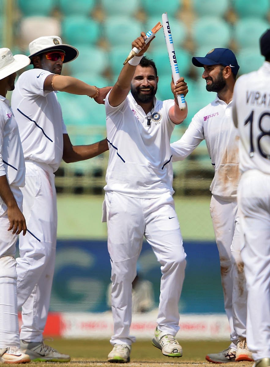 Mohammed Shami holds up a broken stump after dismissing South Africa's Dane Piedt in India's resounding win in Visakhapatnam. PTI