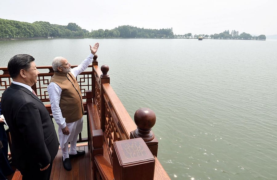 Prime Minister Narendra Modi (R) and Chinese President Xi Jinping looking on in a house boat, at East Lake, in Wuhan, in 2018. (Photo by Reuters)
