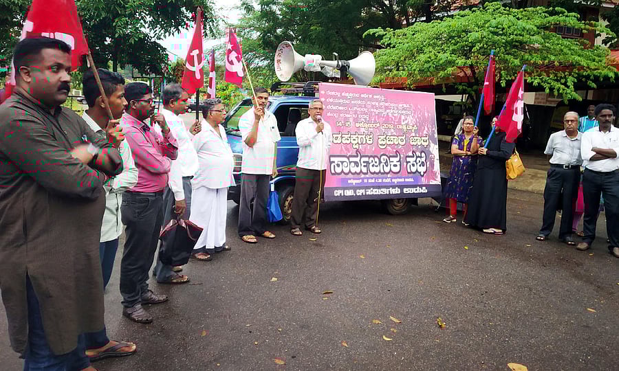 CPM District Secretary Balakrishna Shetty speaks at a protest at Martyrs Memorial in Ajjarakadu in Udupi on Tuesday.