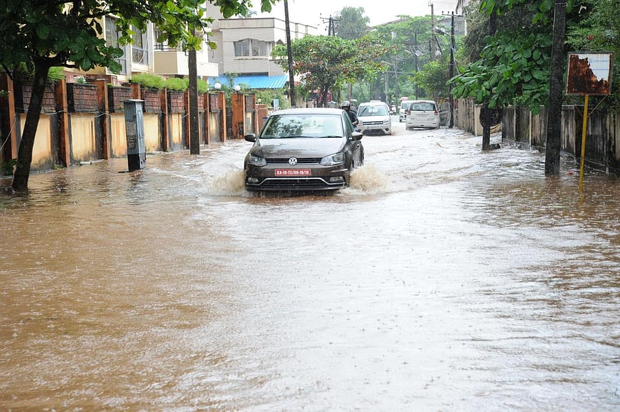 Vehicles wade through the flooded Kodialguthu Road in Mangaluru. DH Photo