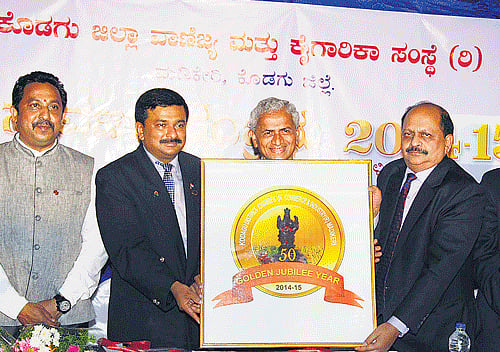 Federation of Karnataka Chambers of Commerce and Industry Senior Vice PresidentDwarakanath releases the golden jubilee logo of Kodagu Chamber of Commerce and Industry, in Madikeri on Tuesday. FKCCI President Sampath Raman, KodaguChamber of Commerce and Industry PresidentBNPrakash and others look on. DH PHOTO