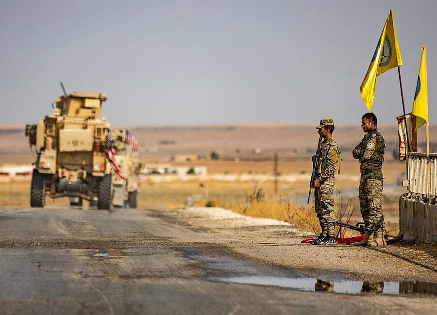 US military vehicles drive on a street in the town of Tal Tamr on October 20, 2019, after pulling out of their base. (Photo by Delil SOULEIMAN / AFP)