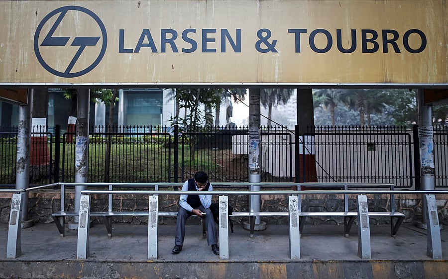 A man waits at a bus-stop with an advertisement of Larsen & Toubro outside the company's manufacturing unit in Mumbai. (Reuters Photo)