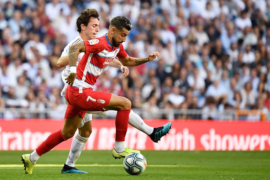 Real Madrid's Spanish defender Alvaro Odriozola (L) vies with Granada's Spanish midfielder Alvaro Vadillo. (AFP Photo)