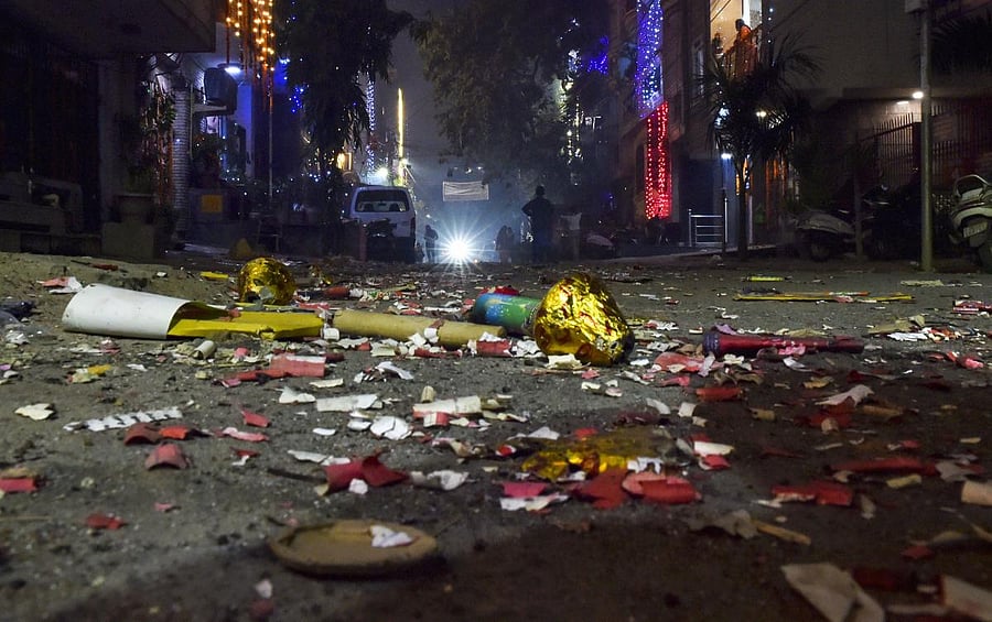 A view of a street littered with firecrackers waste during Diwali celebrations, in New Delhi on Sunday. (PTI Photo)