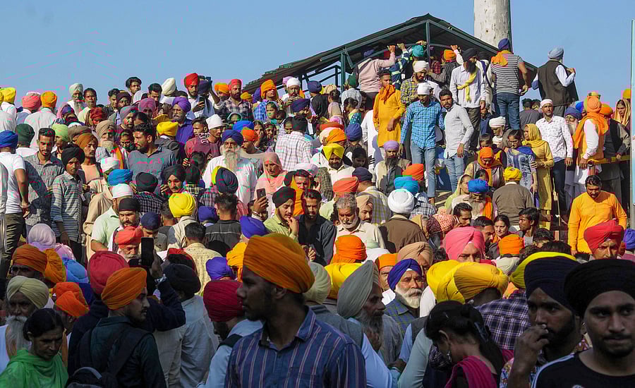 Sikh devotees gather near the zero line in large numbers to pay obeisance as they face Kartarpur Sahib Gurdwara in Pakistan on the day of the inauguration of the Kartarpur corridor at Gurdaspur. (PTI Photo)