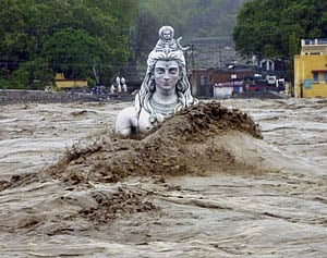 A submerged idol of Lord Shiva stands in the flooded River Ganges in Rishikesh, in Uttarakhand on Tuesday, June 18, 2013. Monsoon torrential rains have cause havoc in northern India leading to flash floods, cloudbursts and landslides as the death toll continues to climb and more than 1,000 pilgrims bound for Himalayan shrines remain stranded. (AP Photo)