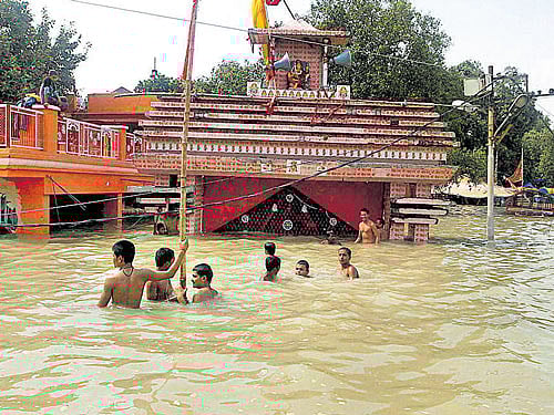 Children swim in the Ganga in front of a submerged temple in Allahabad. PTI
