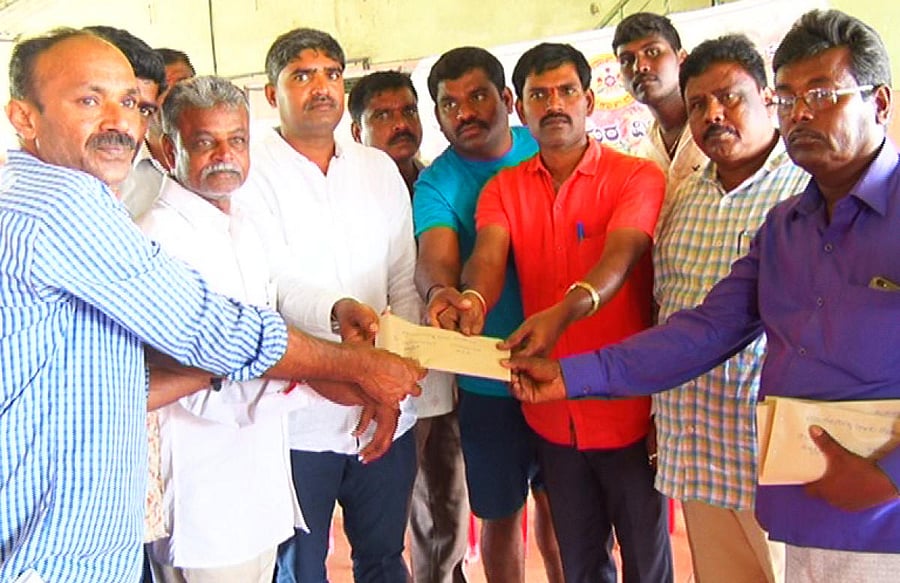 A team from Marenahalli Gram Panchayat distributes aid to flood victims in Madikeri on Sunday.
