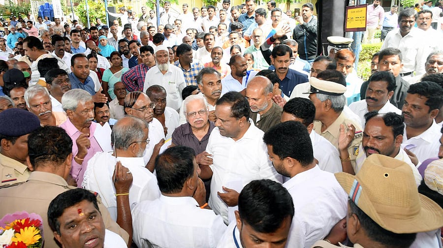 Minister for Urban Development and Housing U T Khader hears people's grievances during MUDA Adalat, at MUDA Office premises, in Mysuru, on Thursday. Minister Sa Ra Mahesh is seen.