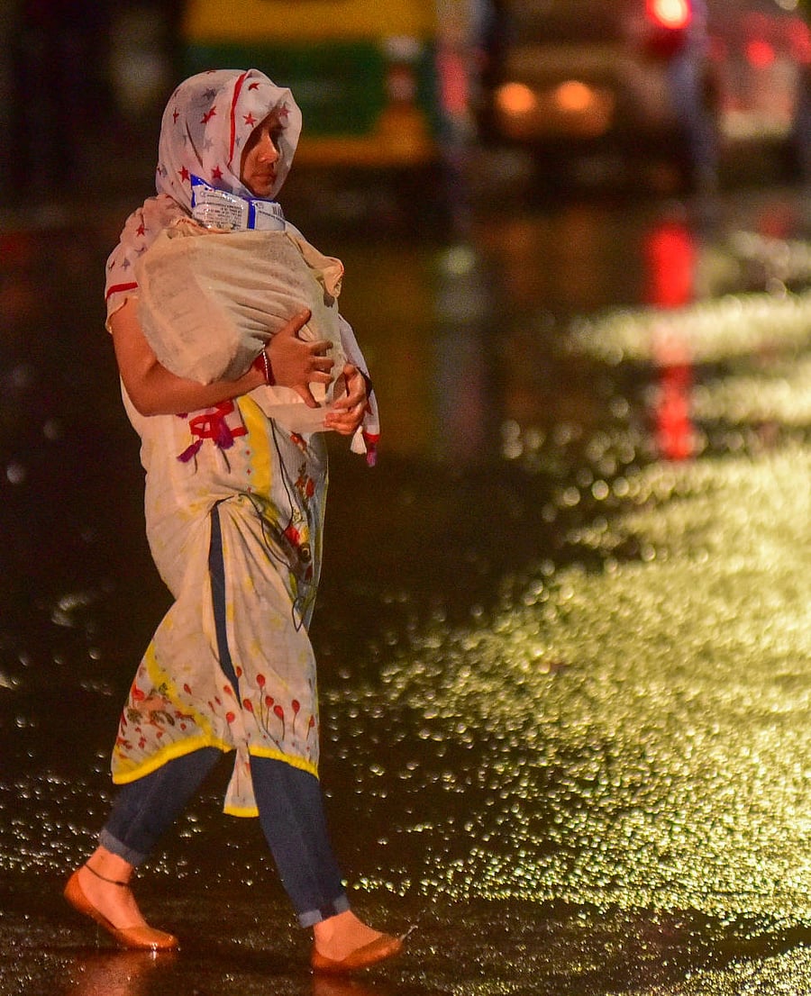 A woman walks through the Residency Road as it rained on Sunday evening. DH photo/Anup R Thippeswamy