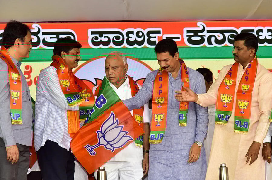 Chief Minister B S Yediyurappa (centre) and party state chief Nalin Kumar Kateel (right) welcome MLA Ramesh Jarkiholi into the party on Thursday. DH Photo/B H Shivakumar
