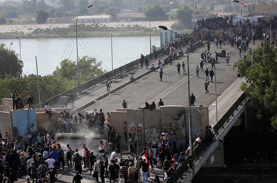 Iraqi demonstrators smash concrete walls at Sinak Bridge during the ongoing anti-government protests, in Baghdad, Iraq November 16, 2019. (REUTERS)