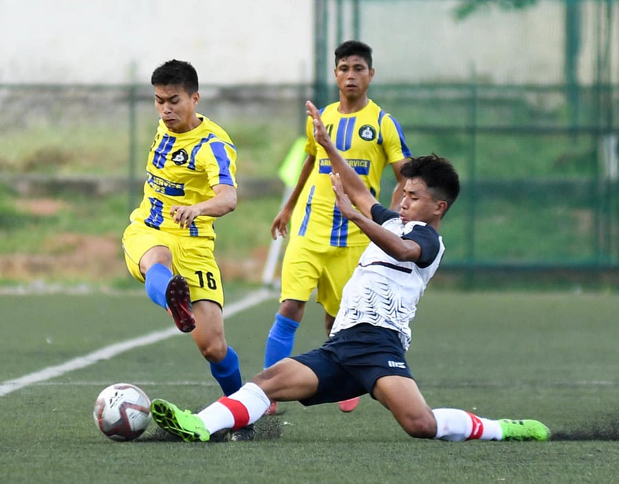 Lethaolen Khongsai of MEG FC (centre) and Oinam Gautham Sing of ASC FC vie for the in the Super Division game on Tuesday. DH PHOTO/BH SHIVAKUMAR