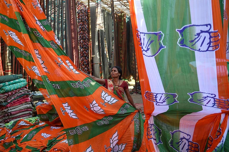 An Indian worker dries colourful materials dedicated to the Bhartiya Janta Party (BJP) and the Congress Party campaigns ahead of India's general election, on the outskirts of Ahmedabad on March 11, 2019. (AFP Photo)