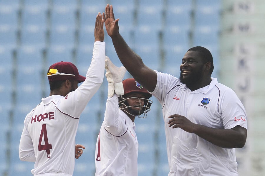 West Indies' Rahkeem Cornwall (R) celebrates with teammates after a dismissal during the second day of the only cricket Test match between Afghanistan and West Indies at the Ekana Cricket Stadium in Lucknow. Photo/AFP