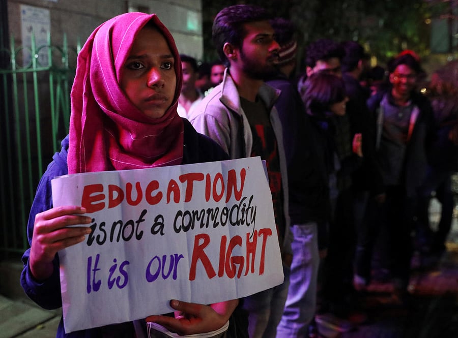 A student holds a placard at a human chain formation to protest against a proposed fee hike in Jawaharlal Nehru University (JNU), in New Delhi. Photo by REUTERS