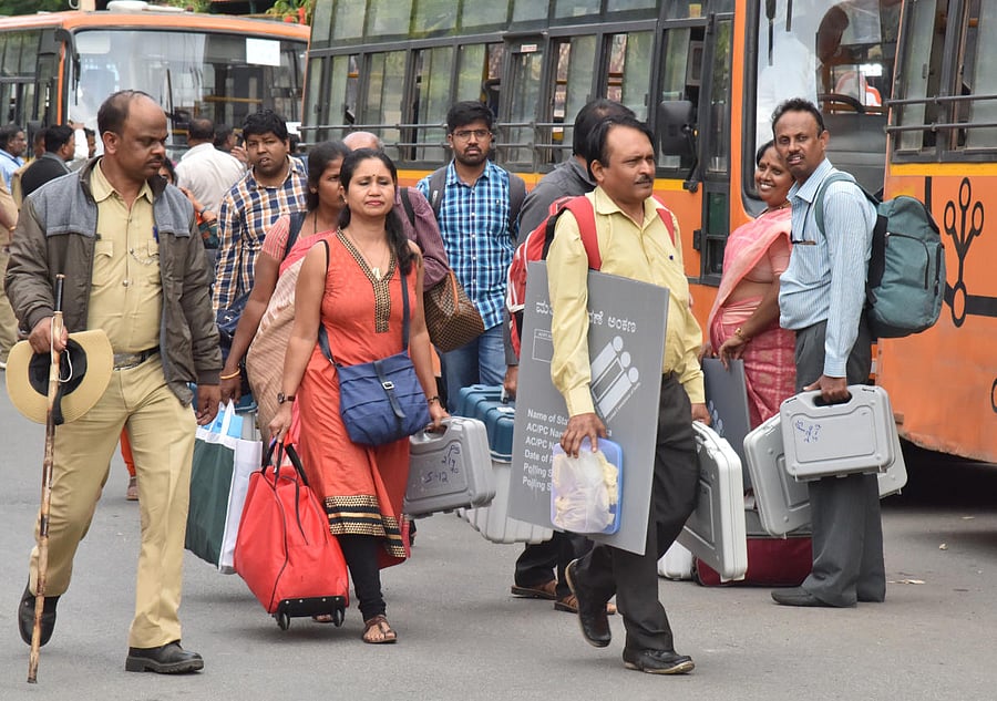 Officials head to a polling booth in Bengaluru on Wednesday. DH Photo/Janardhan B K