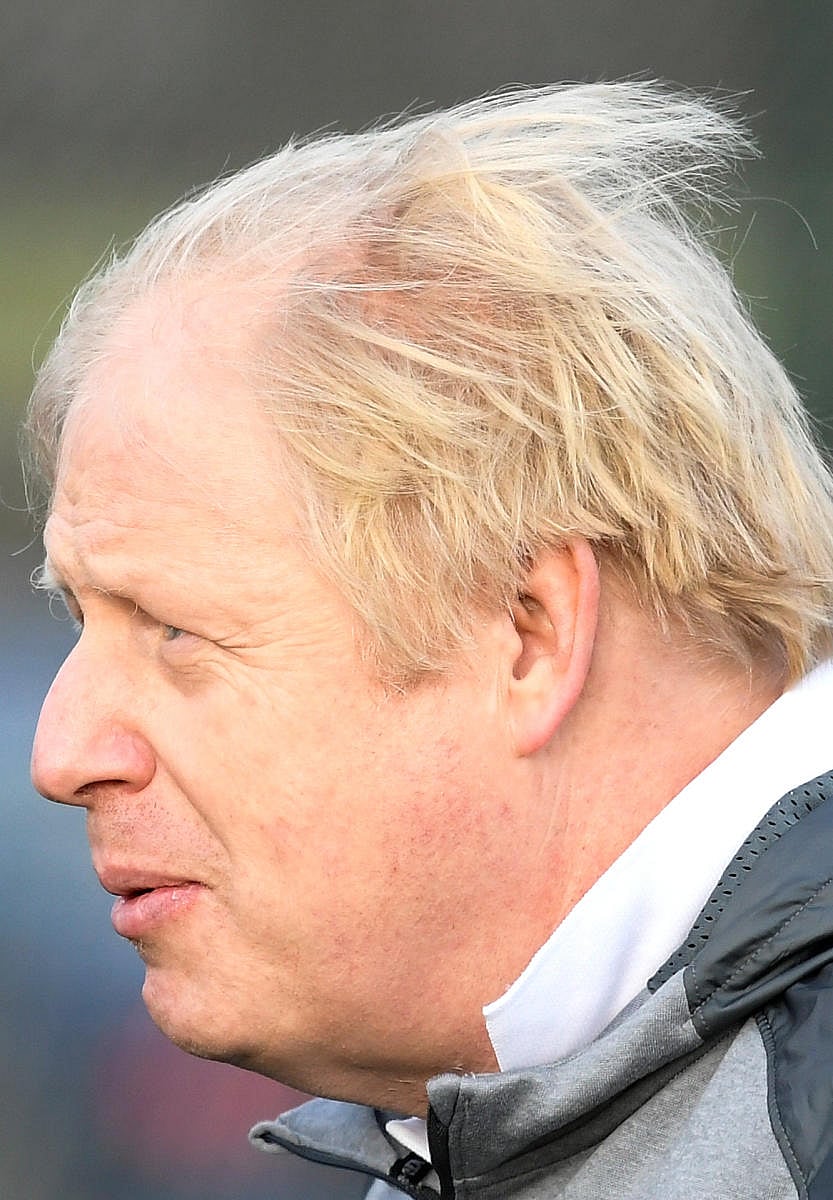 Britain's Prime Minister Boris Johnson takes part in a warm up with a junior girls football team while on the campaign trail in Cheadle Hulme, northwest England on December 7, 2019. (AFP Photo)