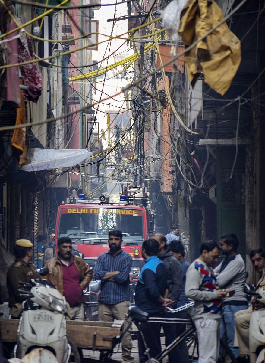  Onlookers stand near the site of a factory at Rani Jhansi Road where a major fire broke out, in New Delhi (PTI Photo)
