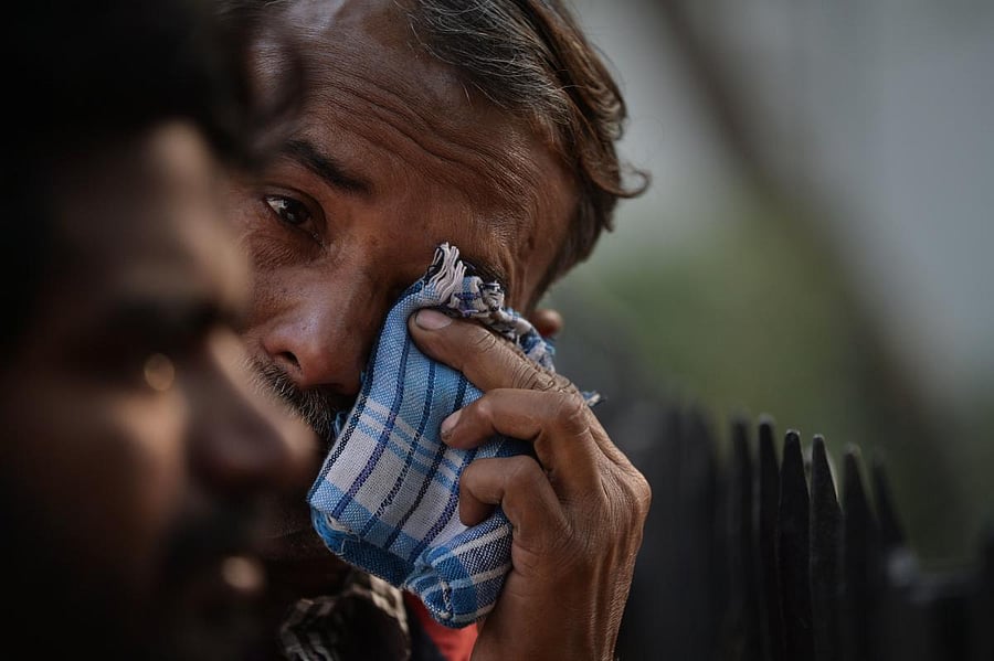 Fire victim relatives wait outside the mortuary of a hospital in New Delhi on December 8. (AFP photo)