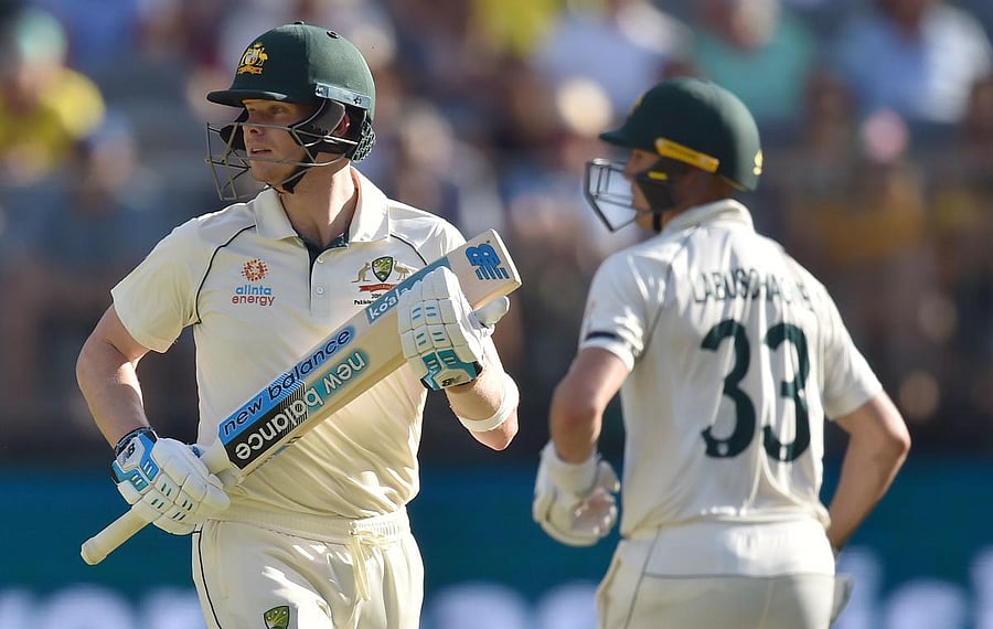 Australia's Steve Smith (L) and Marnus Labuschagne (R) make runs on day one of the first Test cricket match between Australia and New Zealand at the Perth Stadium, in Perth. AFP