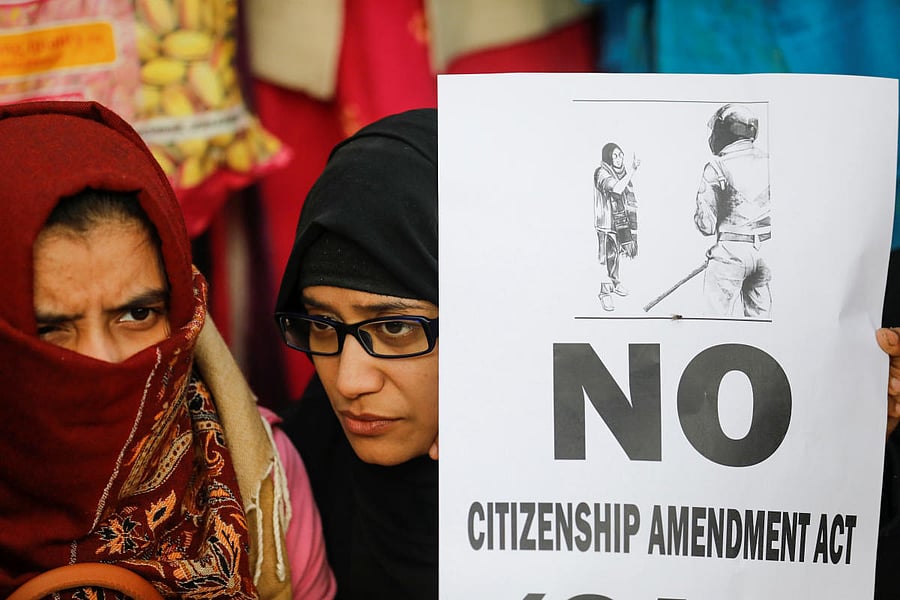 A demonstrator holds a poster during a protest against a new citizenship law, outside the Jamia Millia Islamia University. (Reuters Photo)