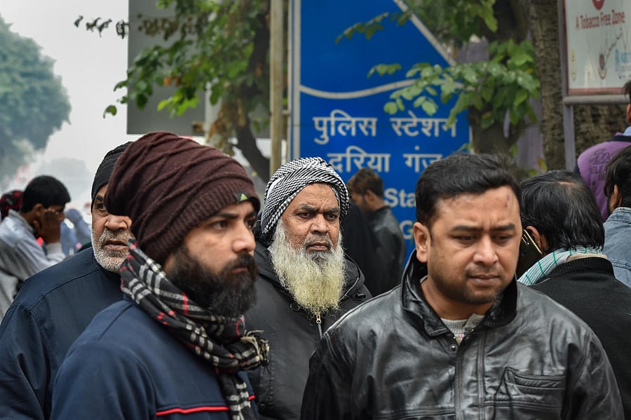 Family members of the people arrested for violence during a rally against the Citizenship Amendment Act (CAA), last evening, wait for their release outside Daryaganj police station, in New Delhi, Saturday, Dec. 21, 2019. (PTI Photo/Manvender Vashist)