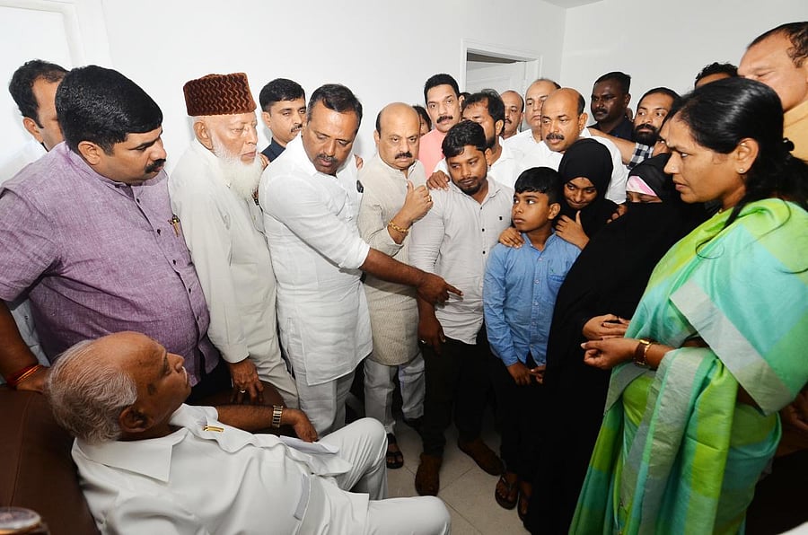 Chief Minister B S Yediyurappa interacts with the families of people who died in the police firing at Circuit House, Mangaluru, on Saturday.